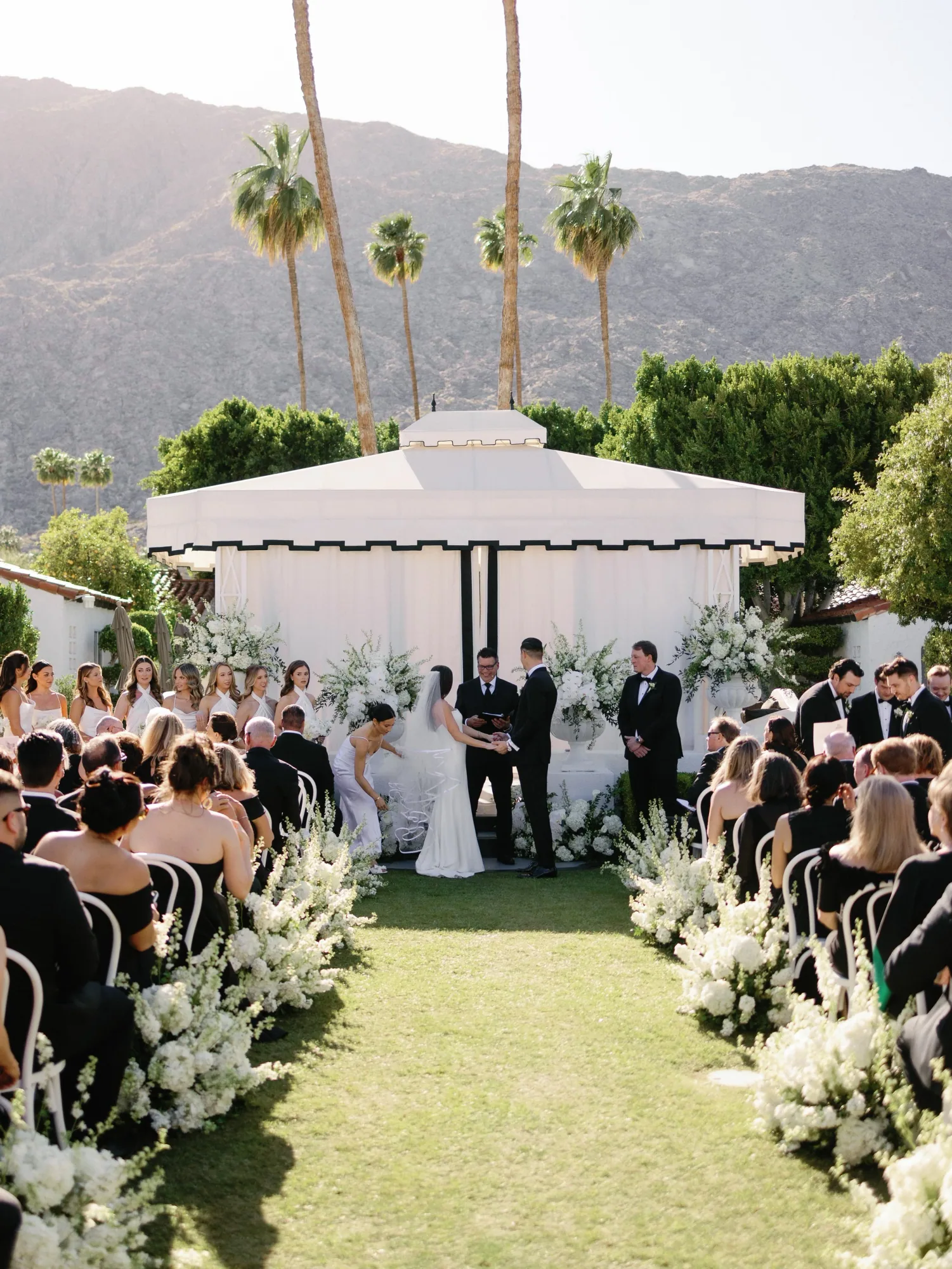 A garden ceremony framed by palm trees and mountains at Avalon Palm Springs.