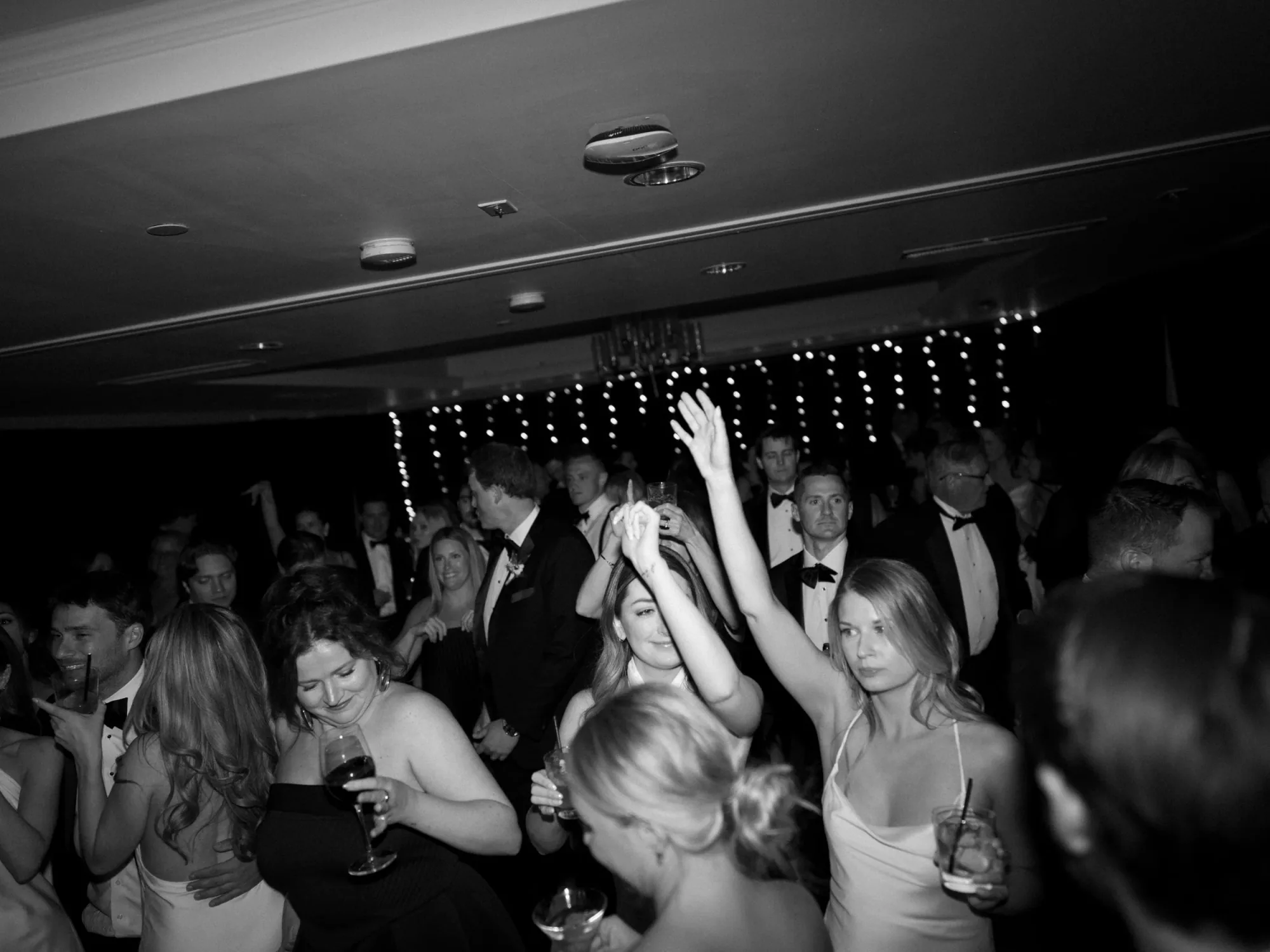 A black and white view of guests dancing in front of the band.