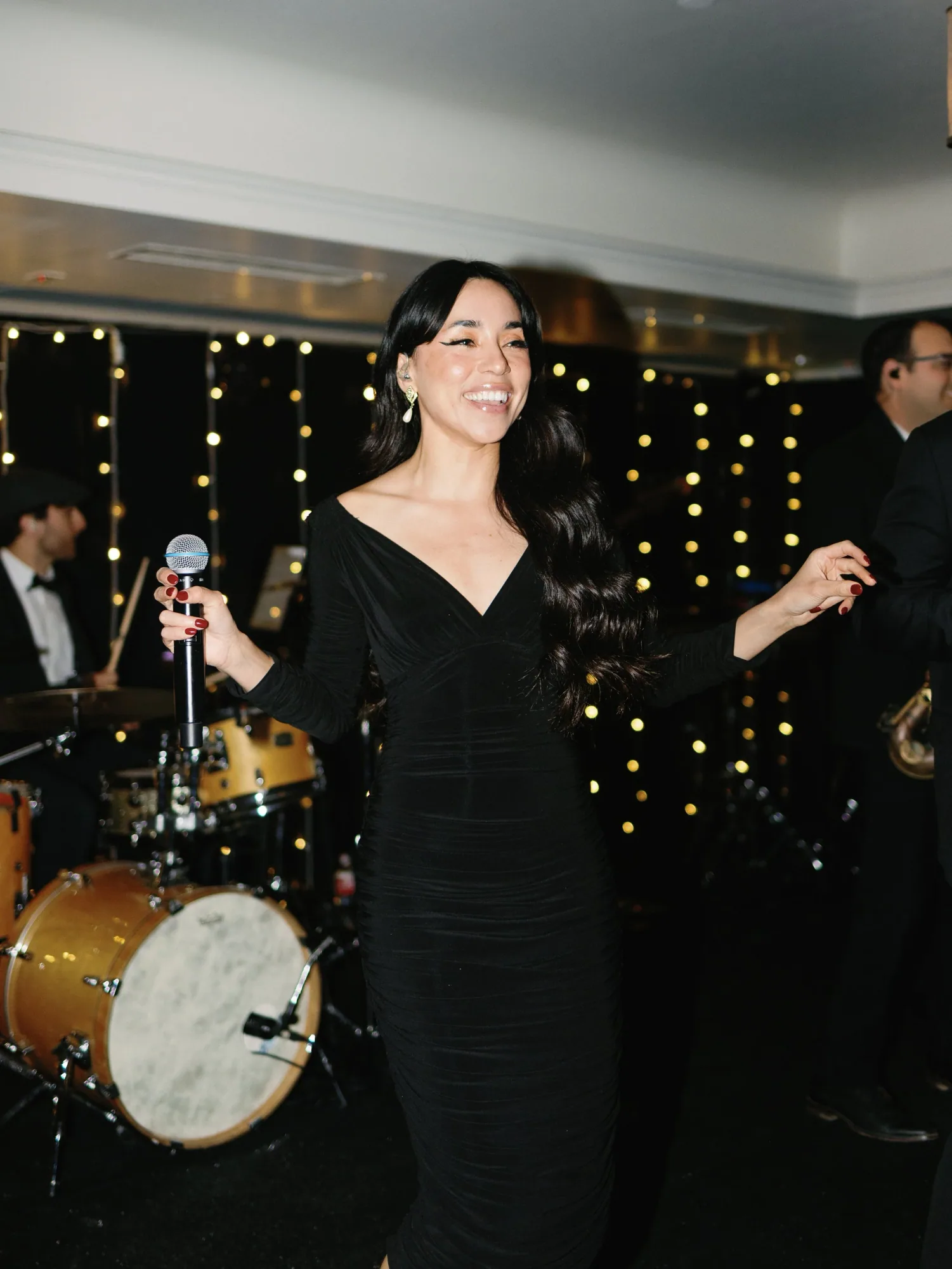 An AMFM vocalist performing against a backdrop of warm lights.