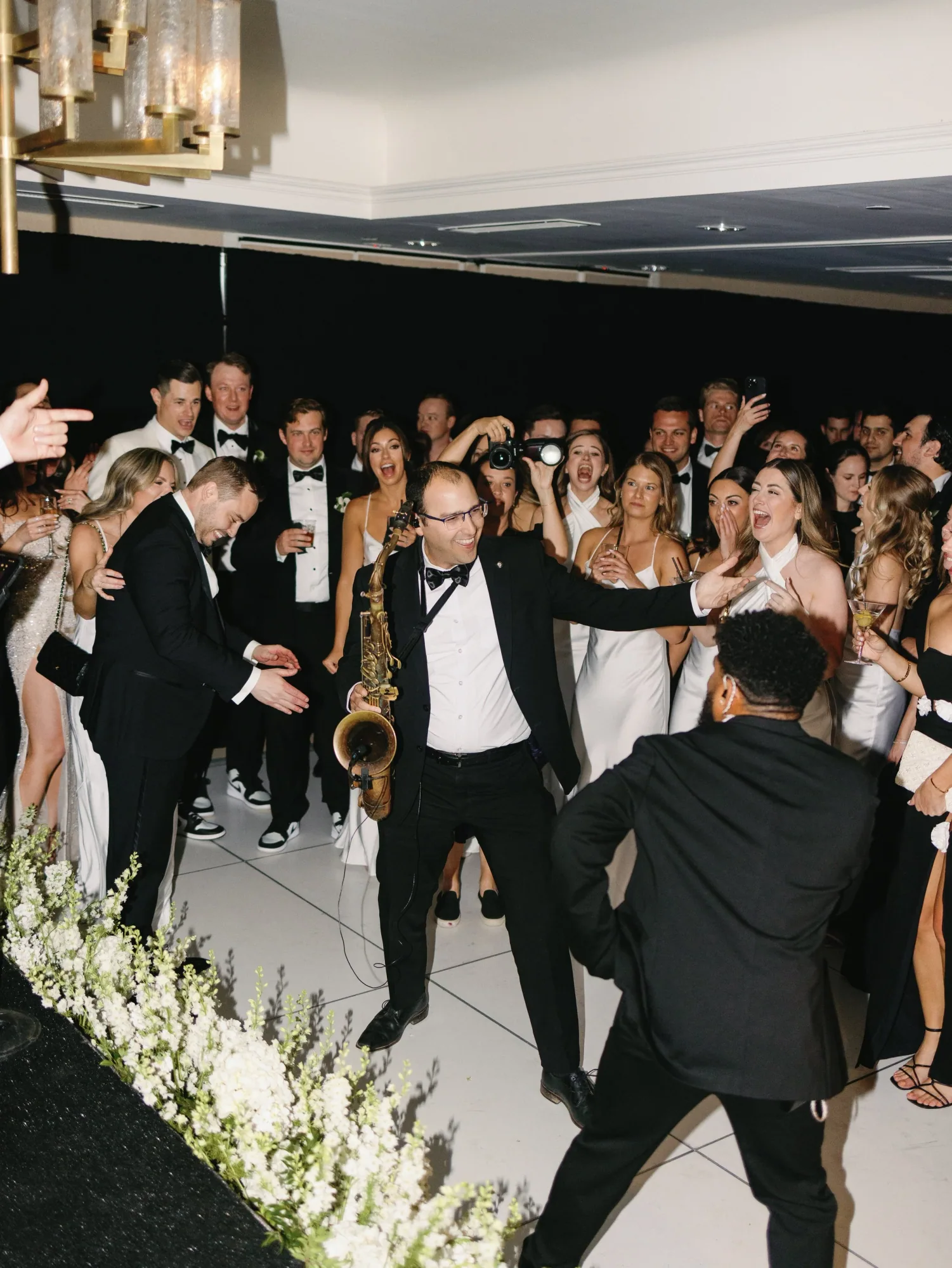 A saxophonist performing in the center of the dance floor.