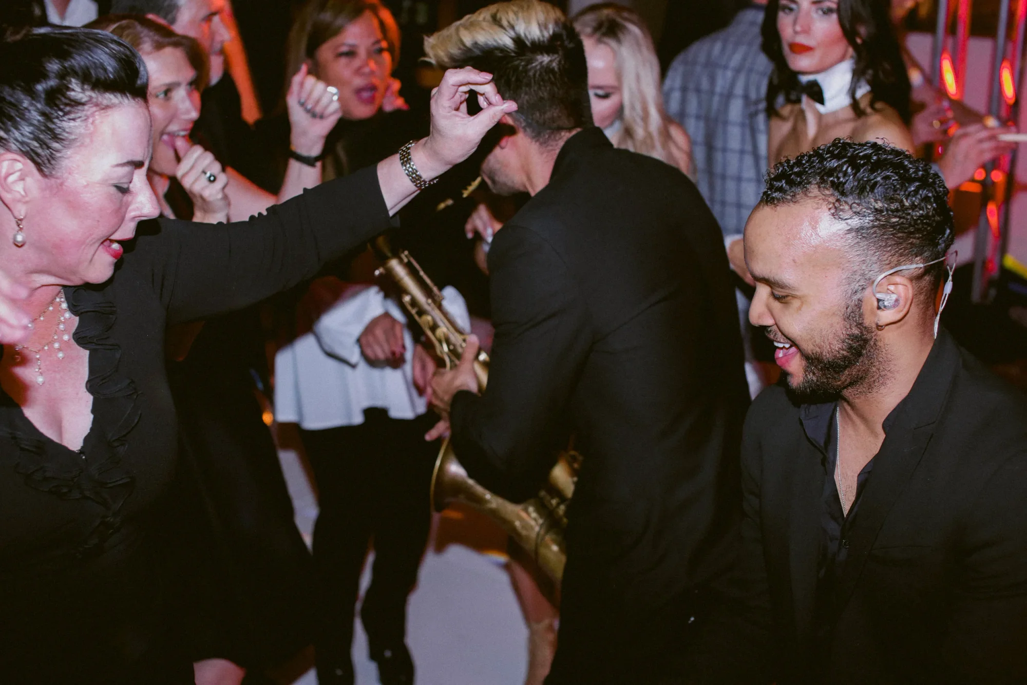 A guest dancing with the saxophonist in the crowd.