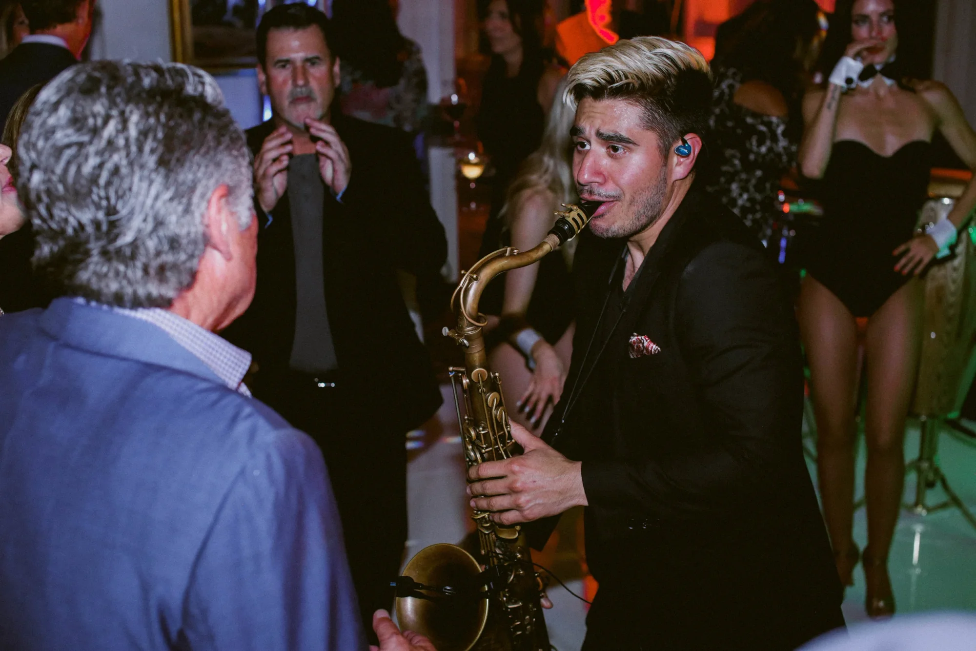 A saxophonist performing directly for guests.