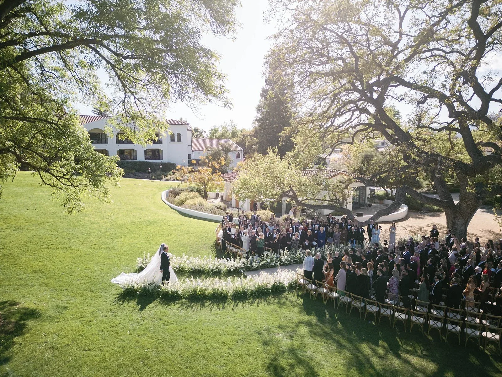 A ceremony beneath mature oak trees on the grounds of Ojai Valley Inn.