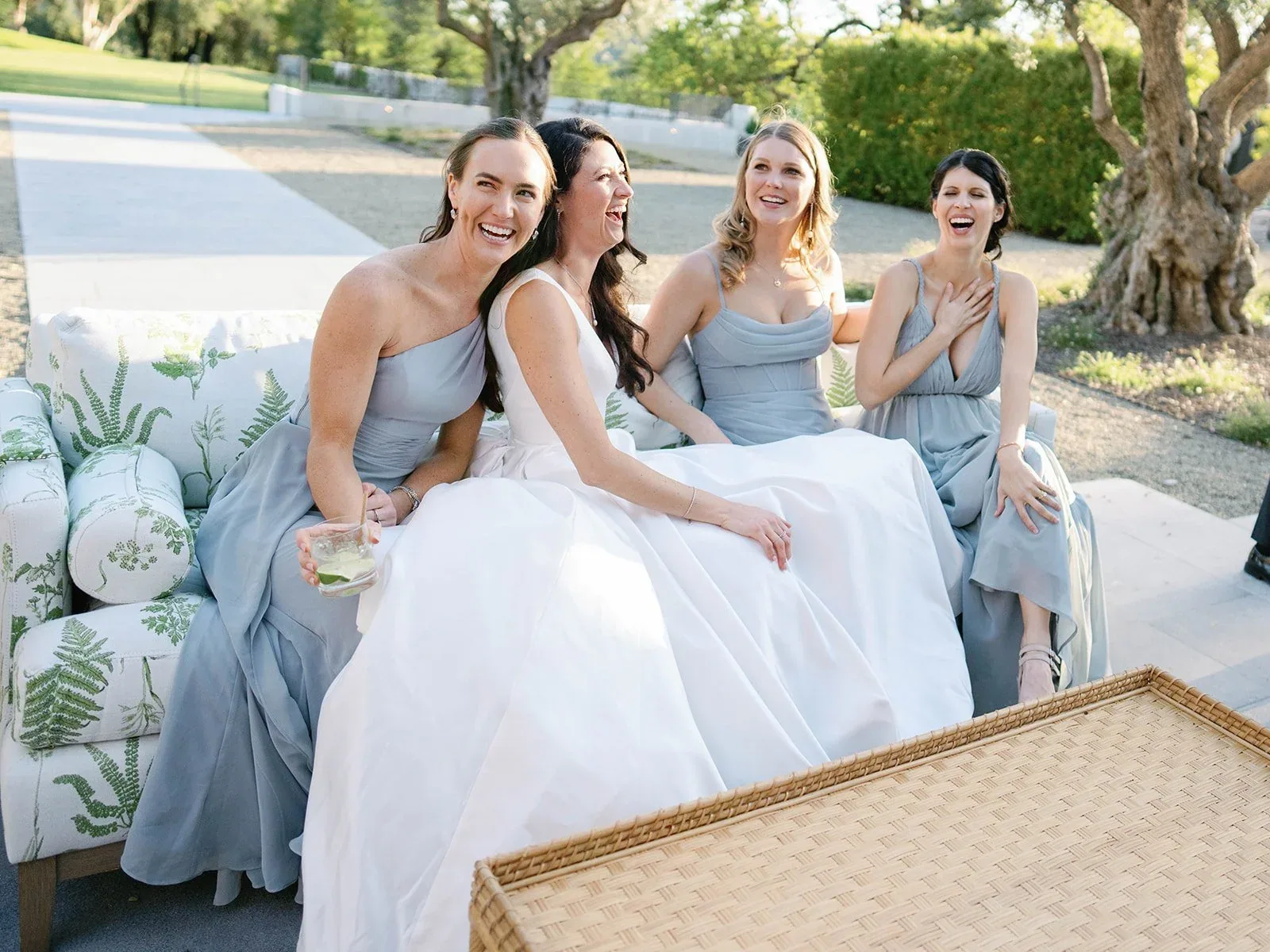 The bride seated with her wedding party outdoors.