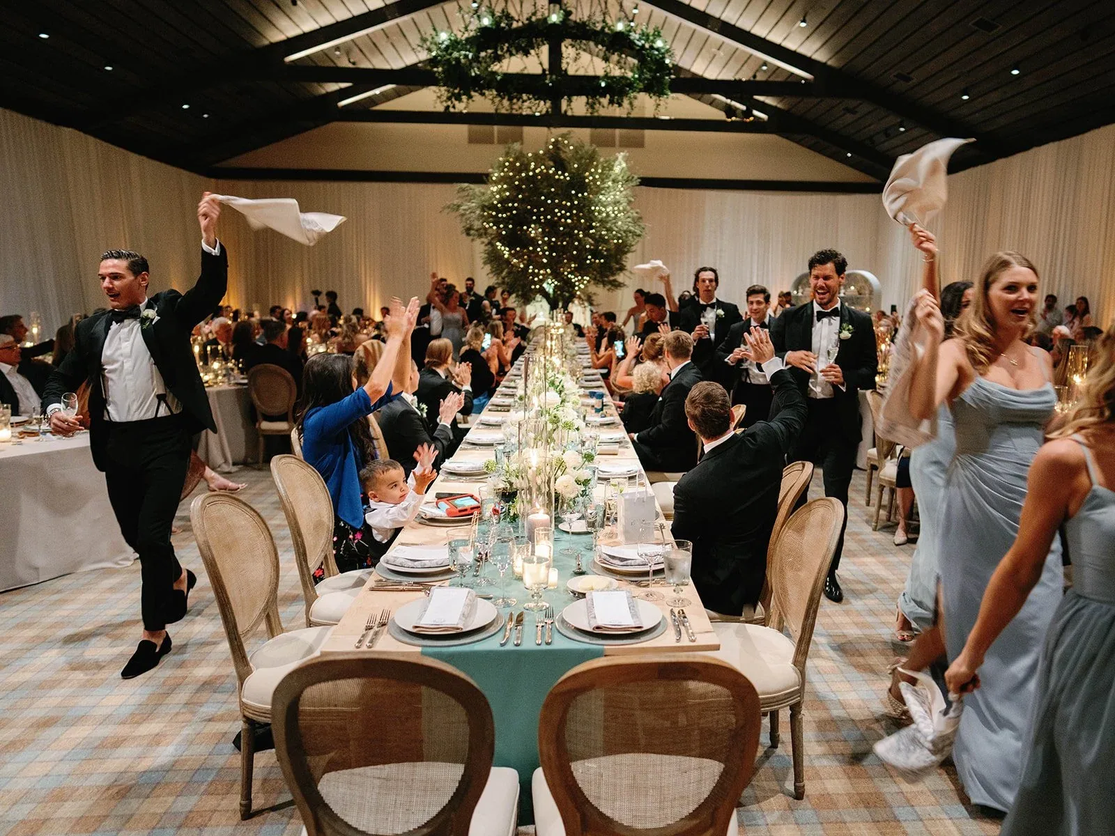 Guests celebrating between long reception tables.