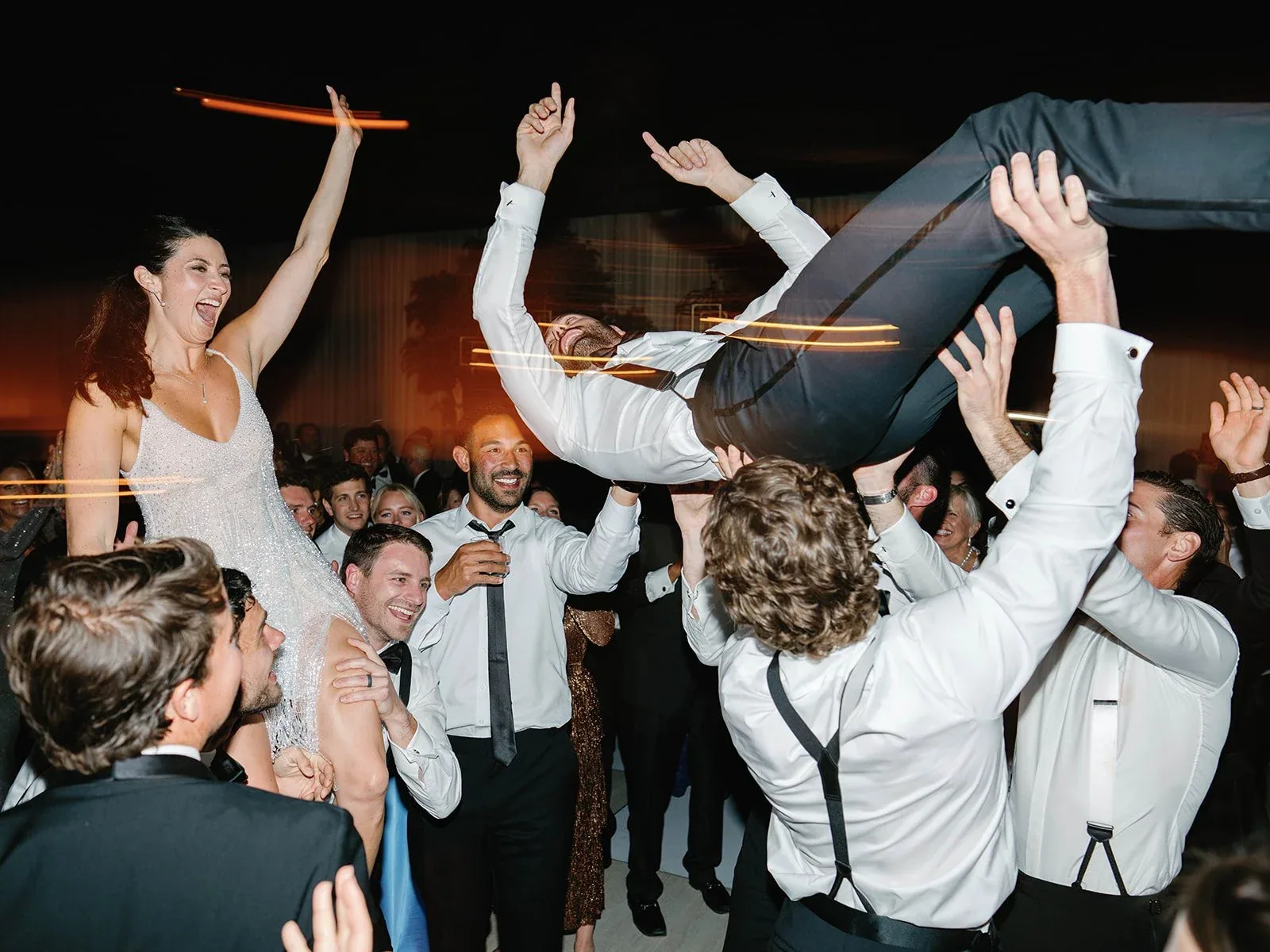 Guests lifting a celebrant above the dance floor.