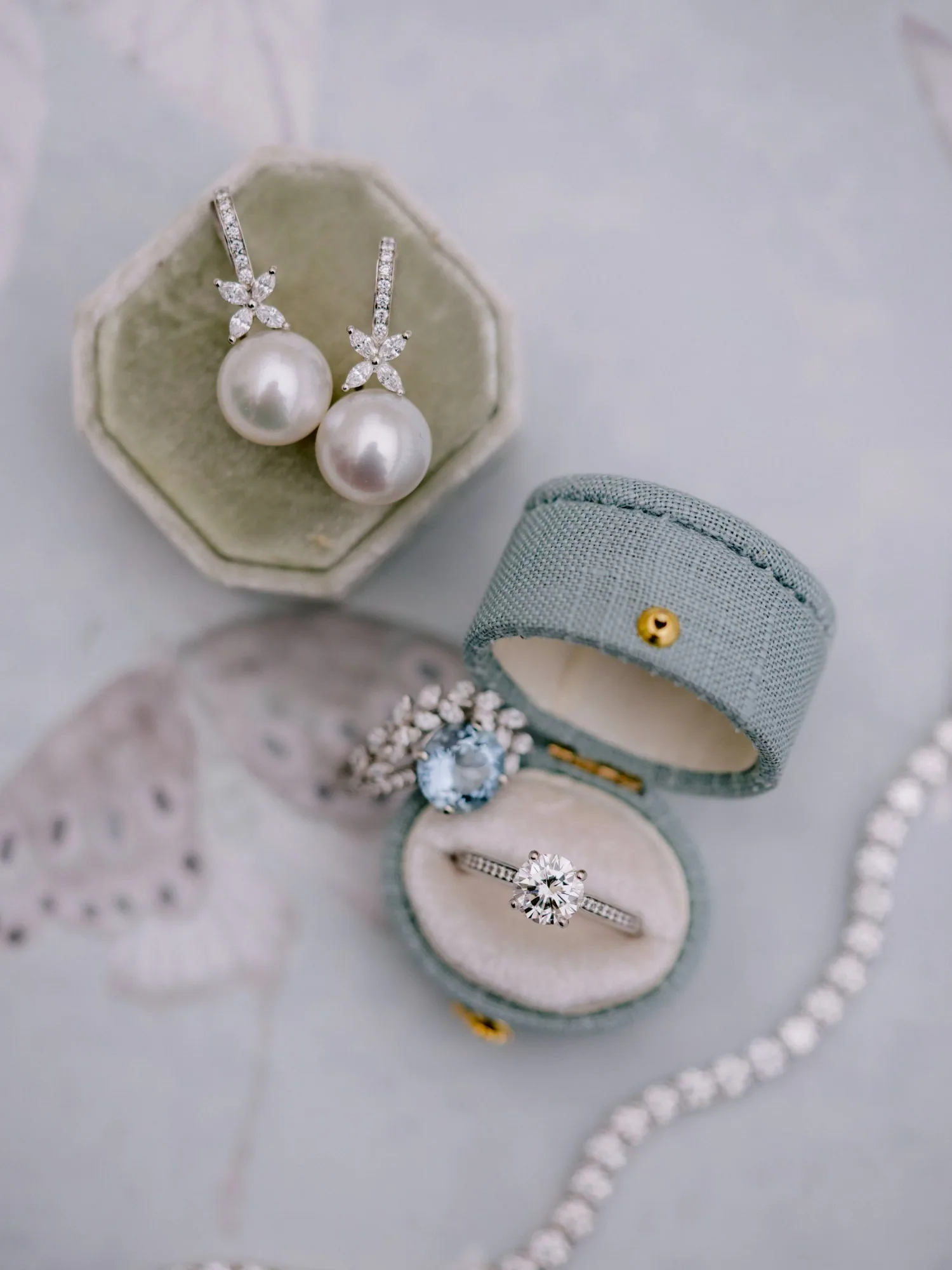 Wedding jewelry and accessories arranged on a pale surface.