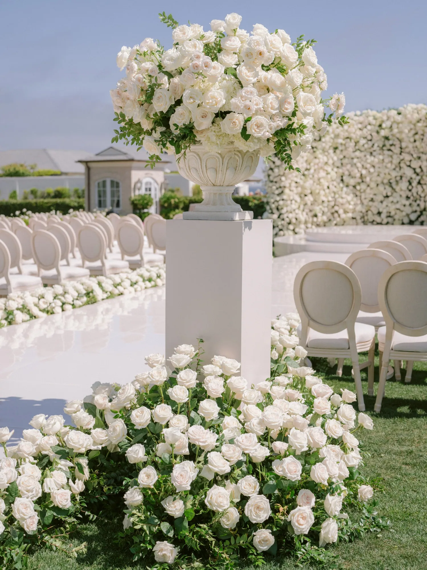 White flowers lining an outdoor ceremony aisle at Rosewood Miramar Beach.