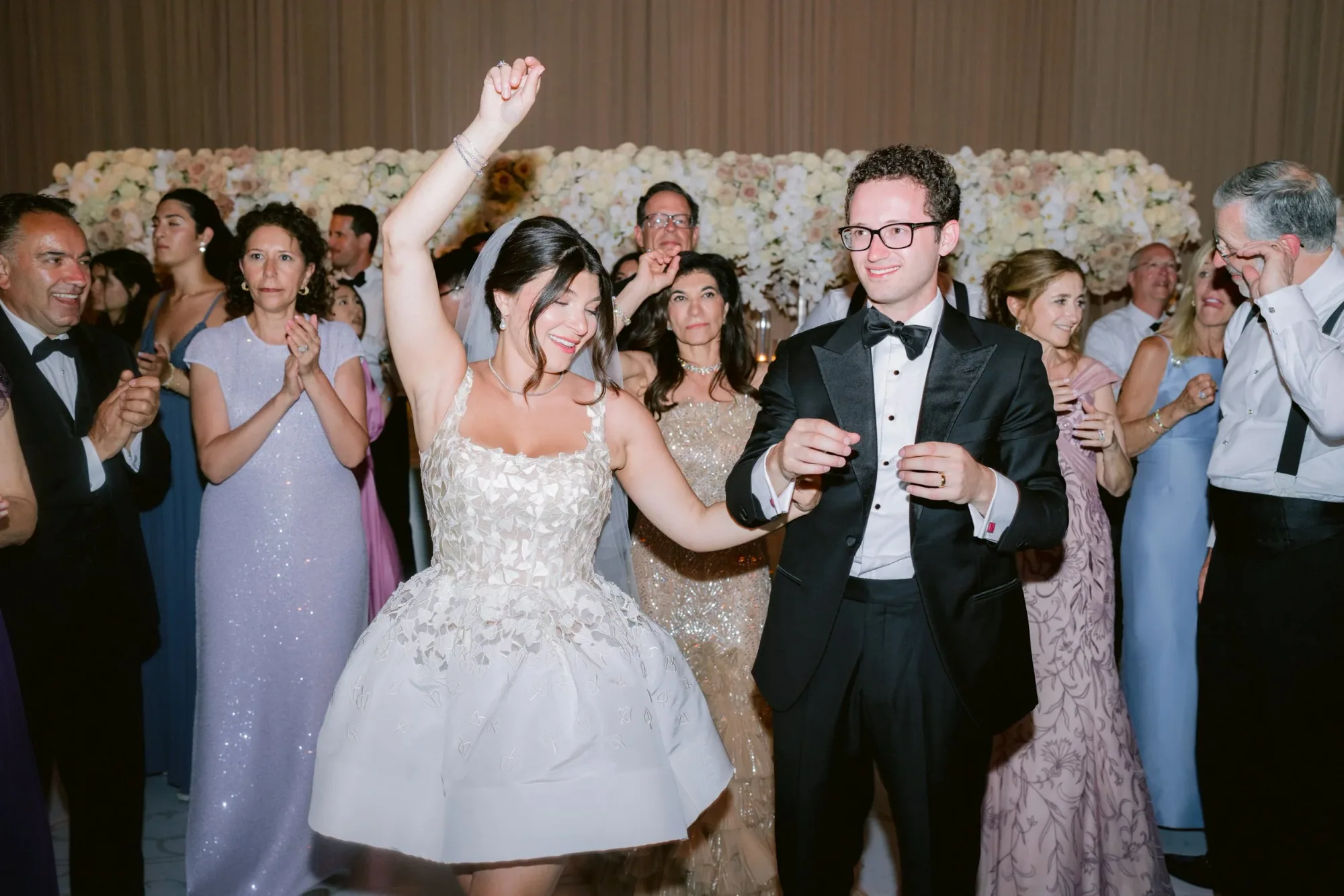 The couple entering a reception surrounded by guests.