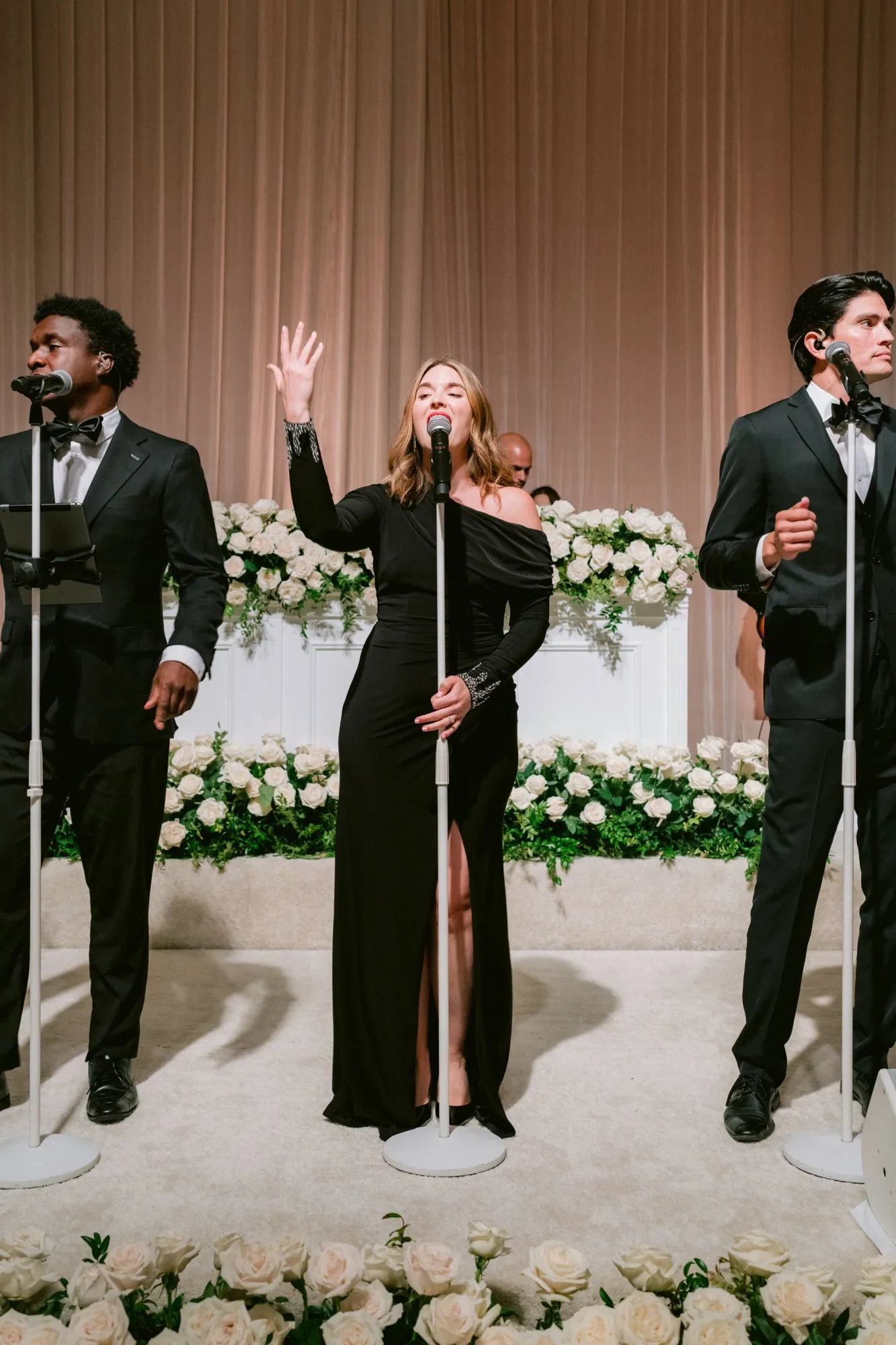 Soultones vocalists performing in front of a white floral installation.