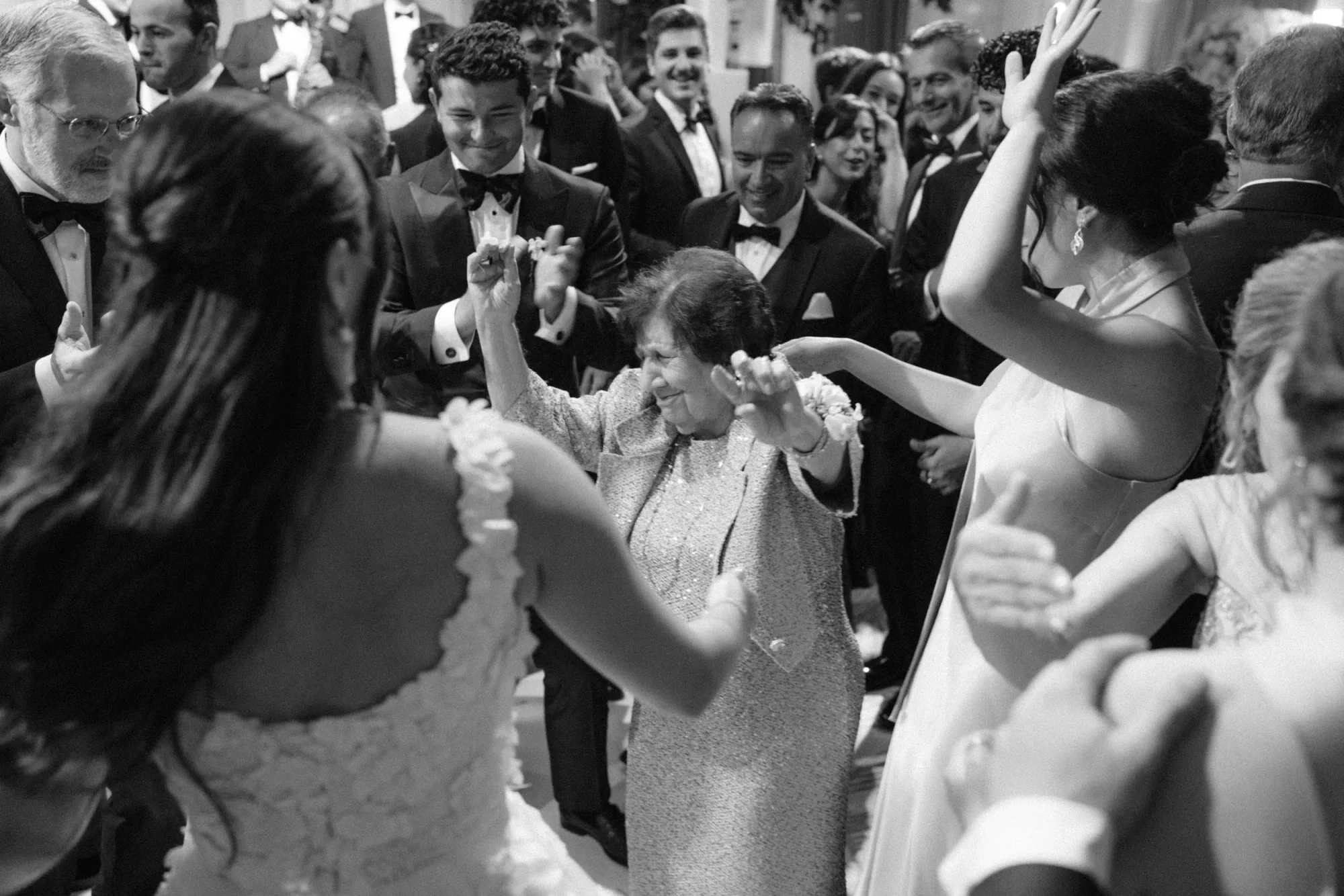 Guests dancing together in a black and white reception photograph.