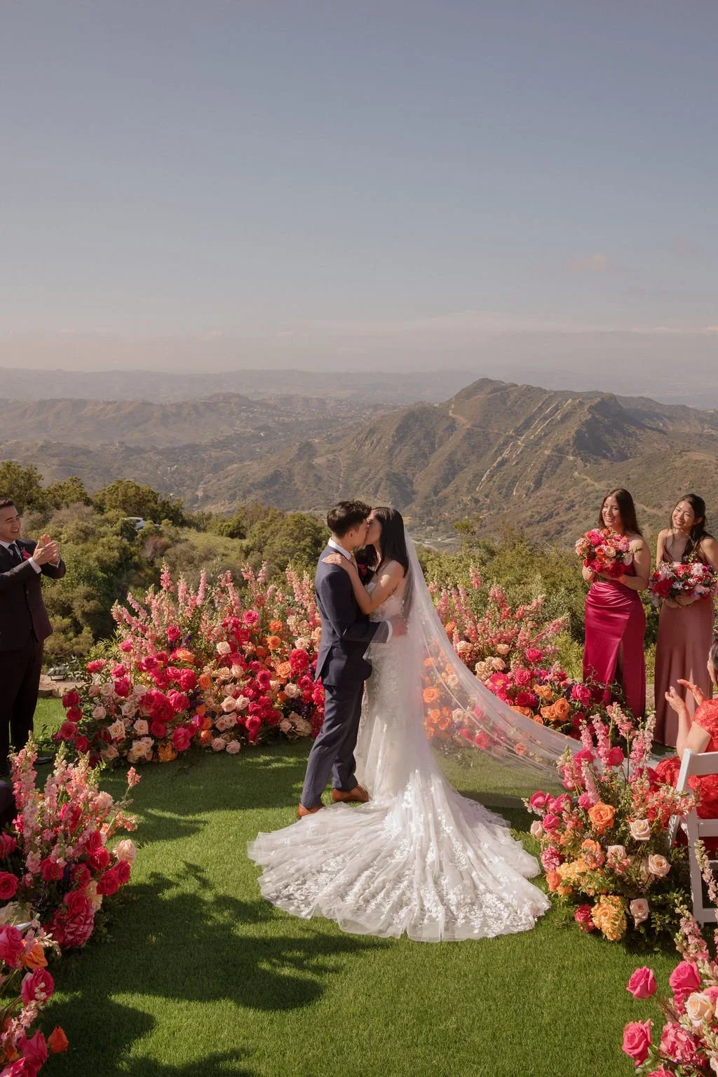 A ceremony framed by vivid flowers and mountain views.