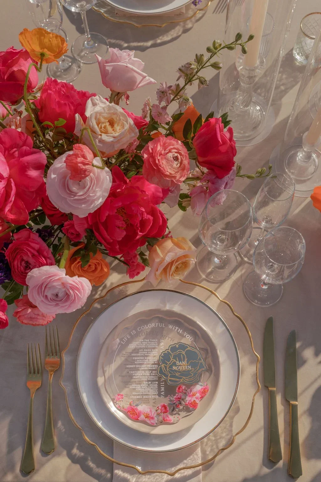 Colorful flowers and custom place settings at the outdoor reception.