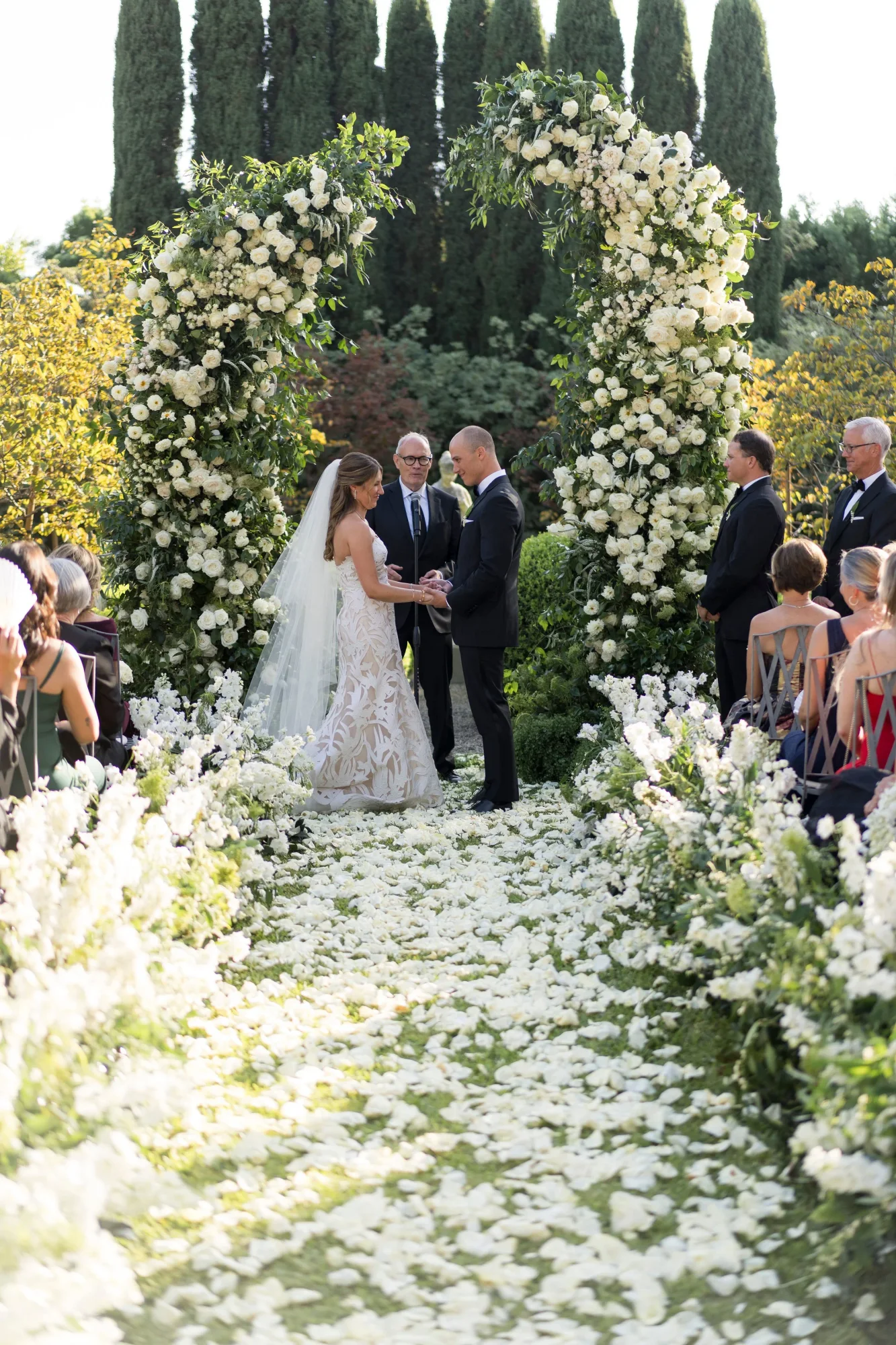 A ceremony surrounded by white flowers and greenery.
