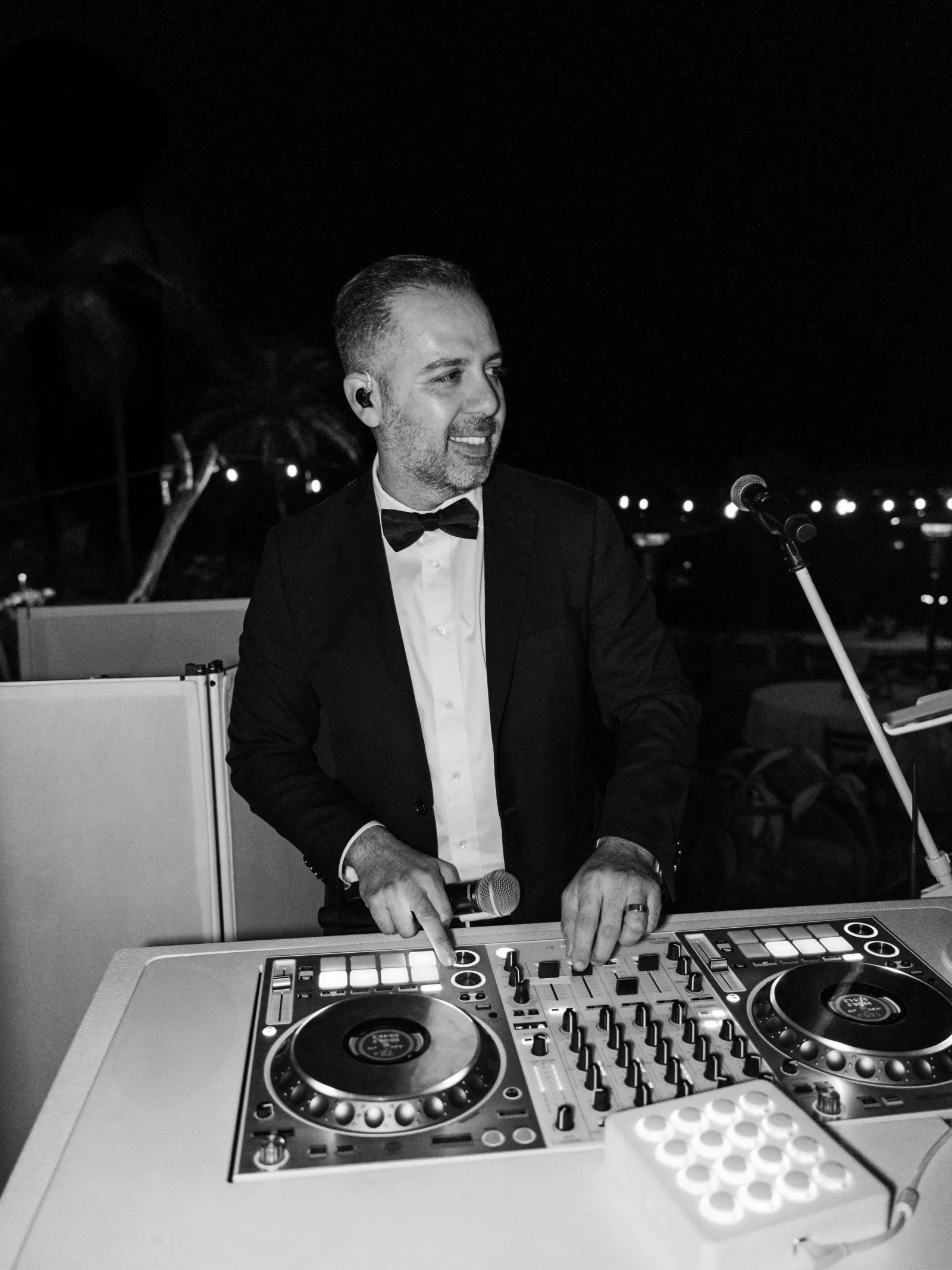 DJ Cisco performing at an outdoor formal event.